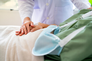 Close up hands of doctor hold and touch to patient hands who has injury with his arm and lie on...