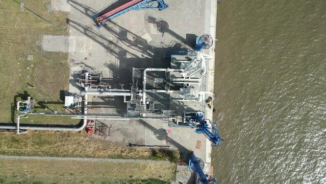 Top down aerial view of a gas and oil unloading terminal with pipeline, future site of an LNG terminal