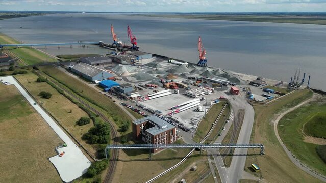 Aerial view of the port of Brunsbüttel on Elbe river, cranes, bulk goods and parts of wind turbines