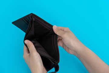 Woman hand open an empty wallet on blue background