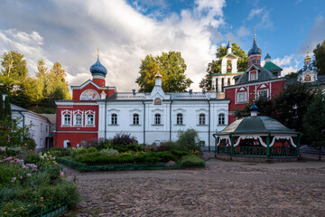 Fototapeta na wymiar Sretensky and Annunciation Churches, the Great Bell Tower, the sacristy and the holy well of the Holy Dormition Pskov-Pechersk Monastery on a sunny summer day, Pechory, Pskov region, Russia