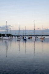 Sailboats in Dinner Key anchorage reflected in calm water of Biscayne Bay in Miami, Florida.