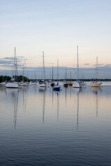 Sailboats in Dinner Key anchorage reflected in calm water of Biscayne Bay in Miami, Florida.