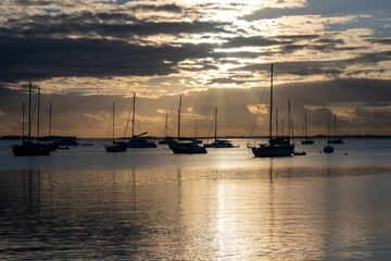 Sailboats in Dinner Key anchorage reflected in calm water of Biscayne Bay in Miami, Florida at...