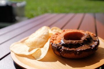 キャンプで食べるチョコオールドファッションドーナツとポテトチップス