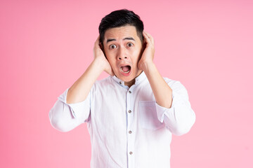 portrait of asian man posing on pink background