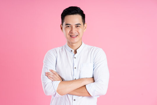 portrait of asian man posing on pink background