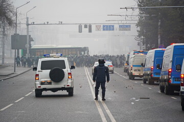 Almaty, Kazakhstan - 01.05.2022 : A policeman stands on a blocked road during the protests. - obrazy, fototapety, plakaty