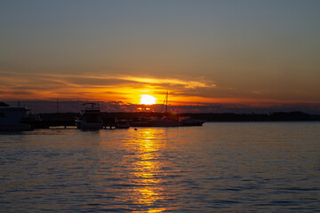 Boat dock in the evening at sunset on the river or lake, boats on the water