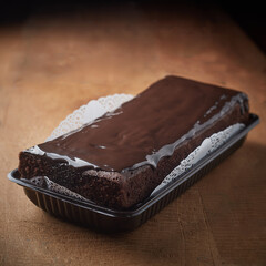 Homemade steamed brownie cake with melted chocolate  on top. delicious cake Selective focus. on wooden table 