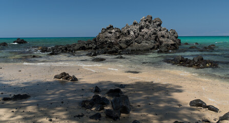 Fototapeta na wymiar Black cliffs at surf line of Puako beach - 2