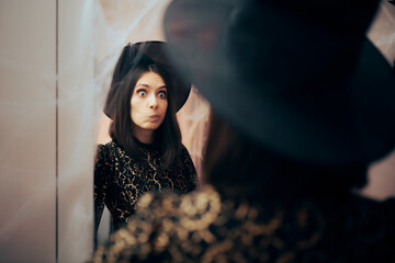 Perfectionist Woman Checking her Costume in Halloween the Mirror. Funny girl trying on an elegant dress for a carnival celebration party
