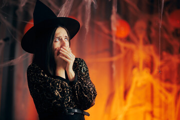 Woman Dressed in witch Costume Frightened by Halloween Decorations. Person terrified by spiders...