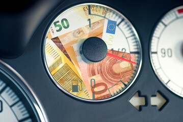 Eine Tankanzeige im Auto und Euro Geldscheine