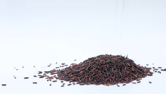 dropping uncooked rice berry on white.