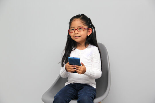 4-year-old latin girl uses her cell phone to make video calls, play video games, send messages, take photos, selfies, watch and record videos as an influencer and have fun in her free time