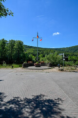 Fototapeta premium Fahnenmast am Mainländle in Gemünden am Main, Main-Spessart in Unterfranken, Franken, Bayern Deutschland bei blauem Himmel