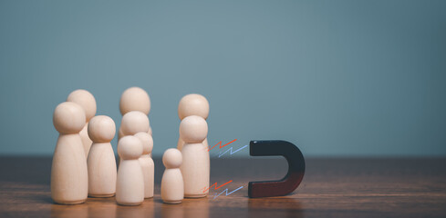The Power of social media marketing, Magnet pulls wooden doll human figure out of the crowd,...