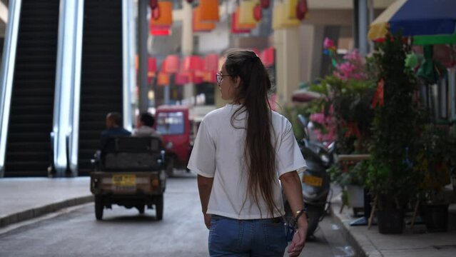 beautiful girl in white t-shirt walks on the streets of Yunnan, China. slow motion. 4K videos.
