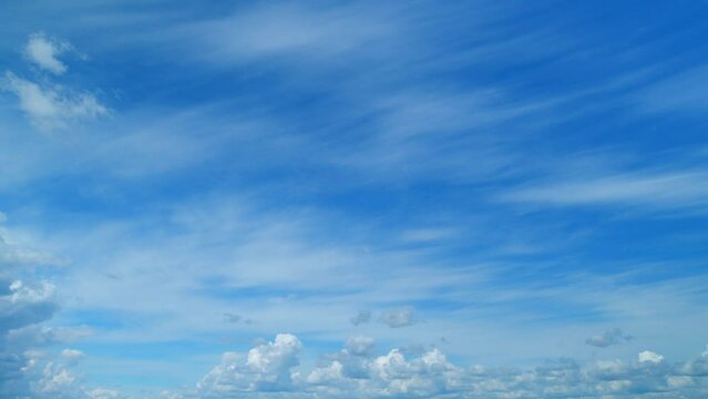 Clouds move in the blue sky. Tropical sky at day time, only white and blue colors. Semi-transparent layers on different height. Timelapse.