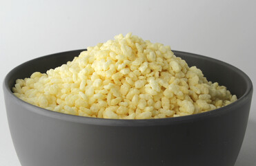 Puffed rice cereal in a grey bowl against a white background