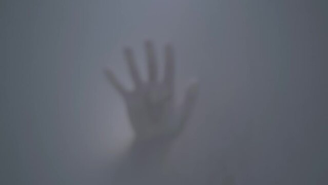 Blurred footage, fogged glass in the shower where the hand appears