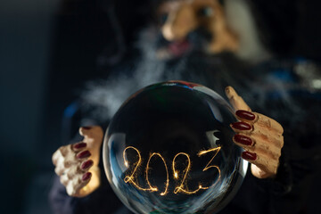 2023 written with sparklers and sparks, inside a crystal ball. - obrazy, fototapety, plakaty