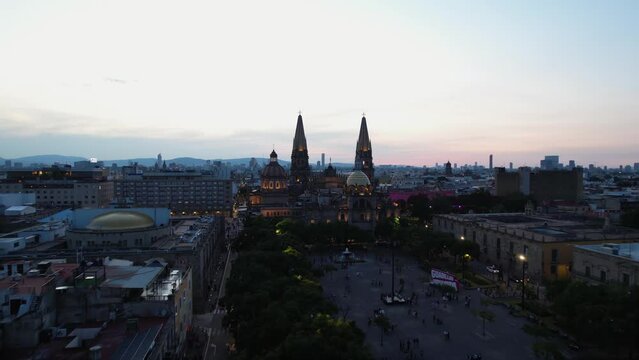 Aerial view over the Plaza de la Liberaci&oacute;n, towards the Guadalajara Cathedral, evening in Mexico - rising, drone shot
