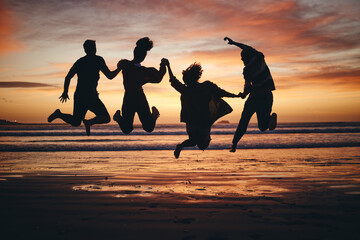 Freedom, jump and silhouette of friends at the beach and travel on brazil vacation for success,...