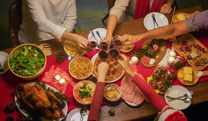 A group of multi ethnic.Portrait of Caucasian and African American black family have a celebration dinner in party with wine, champagne on Merry Christmas Eve Xmas on holiday at home. People lifestyle