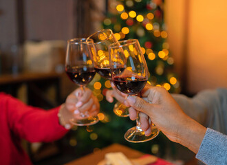 Close up of hands of family have a celebration dinner in party with wine, alcohol champagne on Merry Christmas Eve Xmas on holiday at home. People lifestyle. Cheers