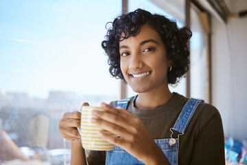 Coffee, relax and creative designer happy at window of startup advertising company. Face portrait of an Indian artist, worker or employee with drink of tea at marketing business in an office