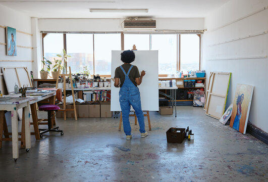Painting, canvas and creative black woman artist in studio workshop inspiration for oil or watercolor design. Creativity, drawing or sketch painter student girl with project idea on easel in New York
