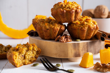 Pumpkin muffins on a wooden table next to a broken muffin. Healthy dietary food, healthy breakfast, dessert