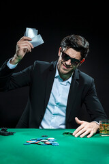 One Emotional Handsome Caucasian Brunet  Pocker Player At Pocker Table With Chips and Cards While Playing and Drinking Alcohol.