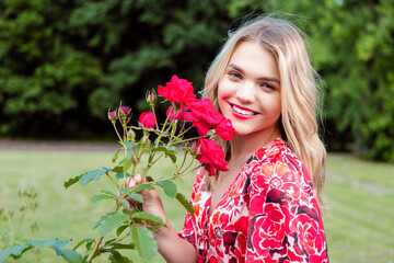 Naklejka premium Beautiful spring girl in fragrant pink flowers in summer blossom park Woman in a blooming garden as Fashion, Cosmetics and Perfumes With Blond Hair
