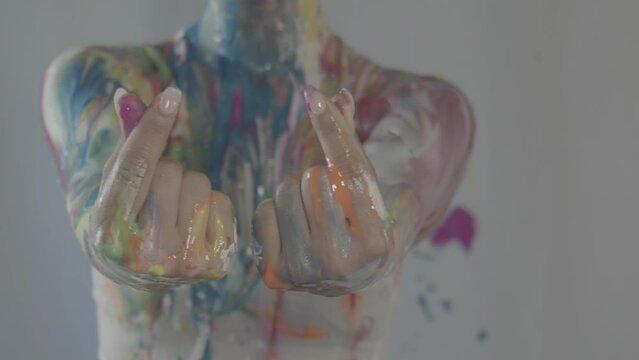 Close up shot of hands and nails of a naked woman covered in body paint, expressionist art. Korean hand symbol for hearts.