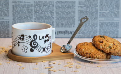 oatmeal cookies and a beautiful mug with musical notes of aromatic green tea, time break