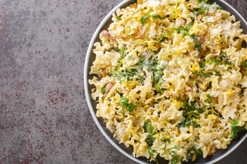 Italian pasta with arugula, pistachios, parmesan cheese and lemon zest close-up on a plate on the table. horizontal top view from above