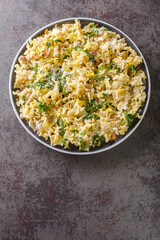 Mafalda Pasta with arugula, pistachios, parmesan cheese and lemon zest close-up on a plate on the table. Vertical top view from above