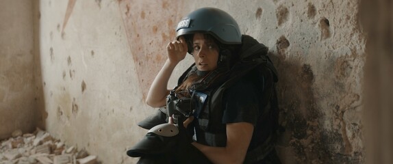 CU Portrait of Caucasian female war journalist wearing protective helmet and bulletproof vest gear...