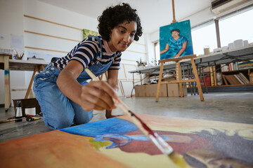 Studio, art and a woman painting on floor in design school with creativity and paint brush. Artist...
