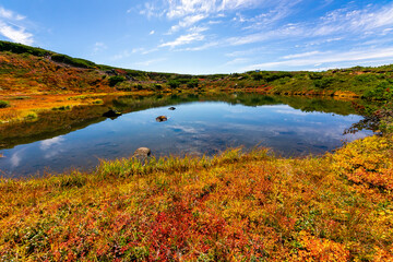 秋の北海道・大雪山の旭岳で見た、カラフルな紅葉と池に映り込む青空