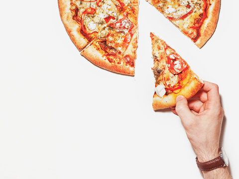 Slice of pizza in hand isolated on white. Top view on pizza. Concept for italian food, street food, fast food, quick bite. Banner