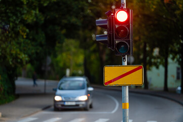 traffic semaphore with red light on defocused background of autumn city, closeup