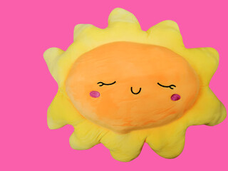 Small pillow in the form of the sun isolated over pink