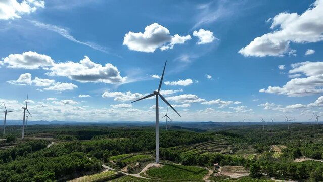 Cinematic backward view of wind turbines rotating at Coll de Moro in Catalonia, Spain. Prores codec