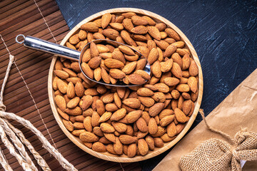 Roasted Delicious Almond on brown wooden table, Almond in wooden plate on wooden table.