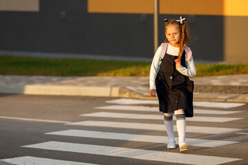 schoolgirl crosses the road at a pedestrian crossing