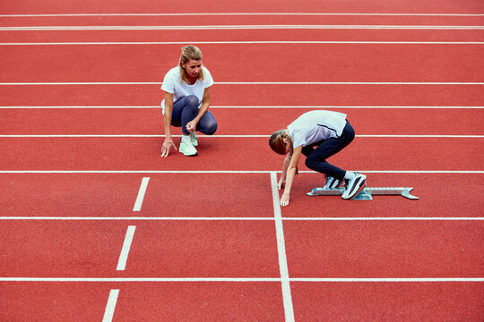 Female Coach Training Athlete. Fit Girl Getting Ready To Run On Treadmill At The Stadium. Concept Of Sport, Achievements, Studying, Goals, Skills. Little Teen Girl Training Outdoor.